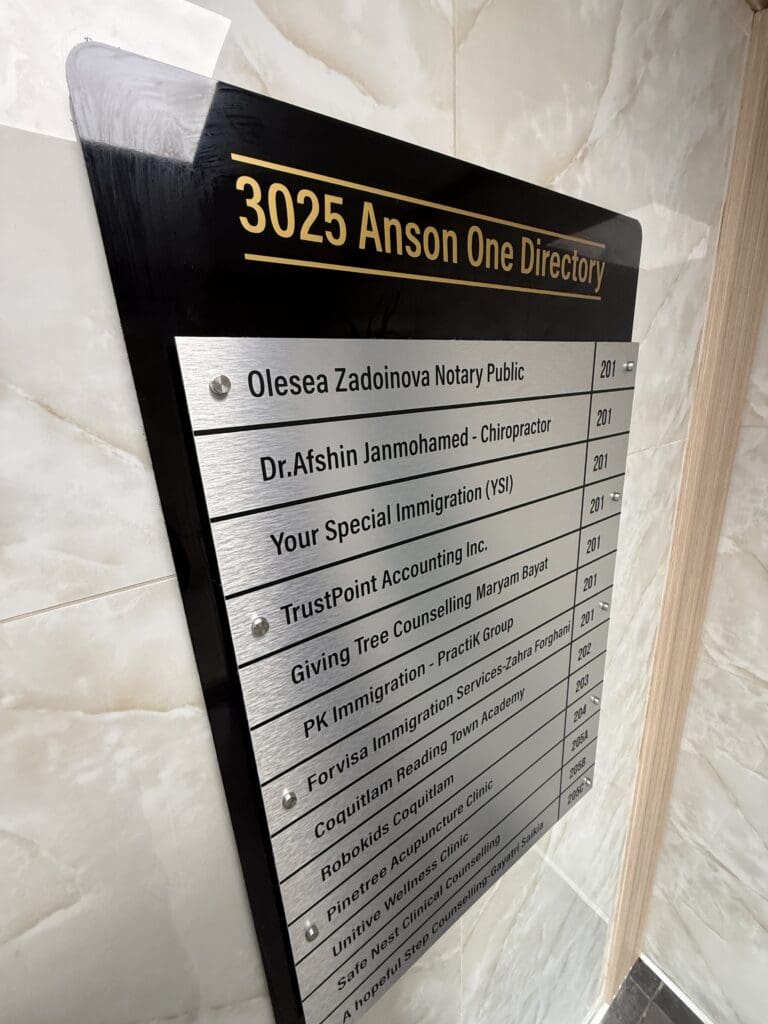 Installed 3025 Anson One building directory with a black backing, gold header and brushed aluminum tenant panel.